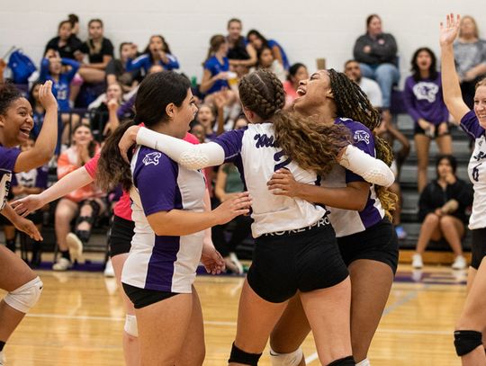 The Elgin High School varsity volleyball team celebrates together on Sept. 20, 2022, after the Lady Wildcats won a set at home vs. Cedar Creek High School. Photo by Erin Anderson