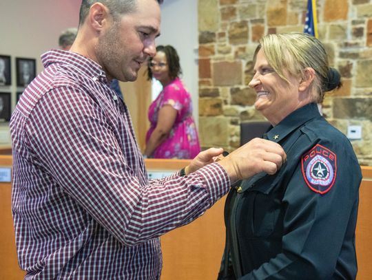 Vicky Steffanic has her police chief badge pinned on her uniform by husband Matthew Steffanic during the Bastrop City Council meeting April 11. Courtesy photo / City of Bastrop