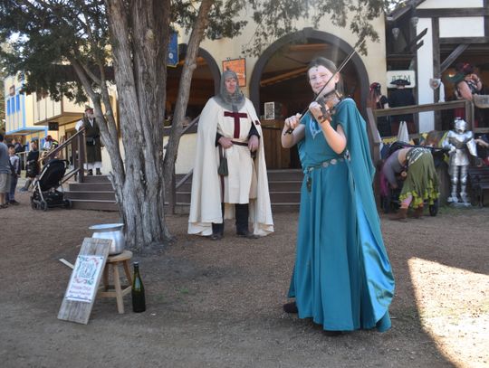 Princess Emlyn plays at the Sherwood Forest Faire in Paige March 4 as a knight looks on. Photo by Fernando Castro