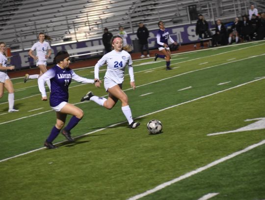 Katelyn Muñoz battles a Georgetown player for possession. Photo by Quinn Donoghue