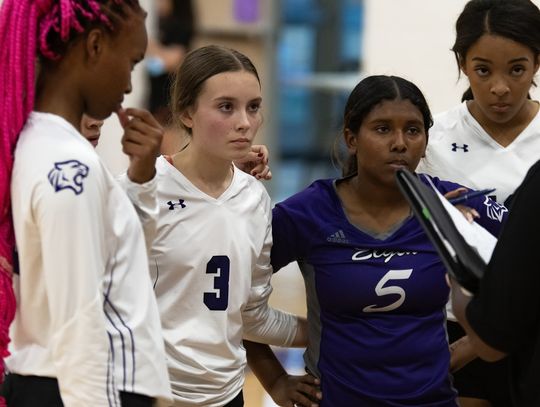 Elgin High School varsity volleyball freshman Meta Elliott (3) and sophomore Trinity Martinez (5) listen to head coach Patricia Rivers-Taylor (right) on Aug. 25 during a Lady Wildcats’ home match vs. Meridian World School. Photo by Marcial Guajardo