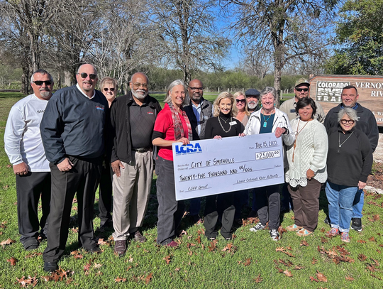 LCRA representatives present a $25,000 grant to Smithville officials for new signs at Vernon L. Richards Riverbend Park. The grant is part of LCRA’s Community Development Partnership Program. Pictured are, from left, Jack Page, Smithville director of public works and utilities; Robert Tamb...