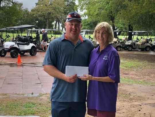 Robert Justice of TriCounty Feed accepts the second place reward from Ruth Hyatt following the Relay For Life of Elgin Golf Tournament. Photo courtesy of Ruth Hyatt