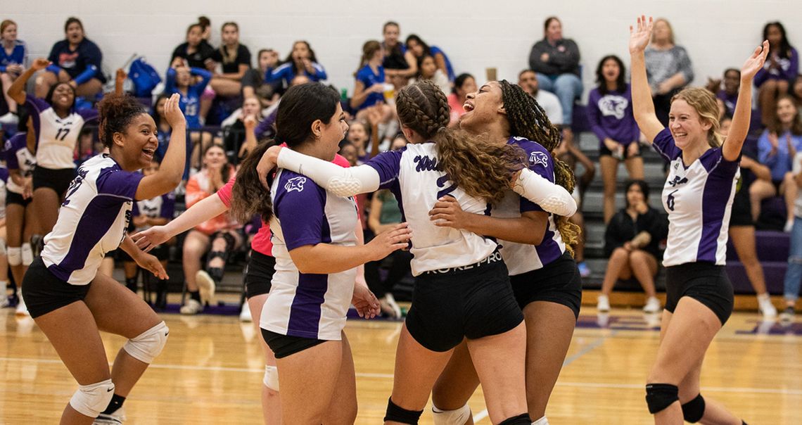 The Elgin High School varsity volleyball team celebrates together on Sept. 20, 2022, after the Lady Wildcats won a set at home vs. Cedar Creek High School. Photo by Erin Anderson