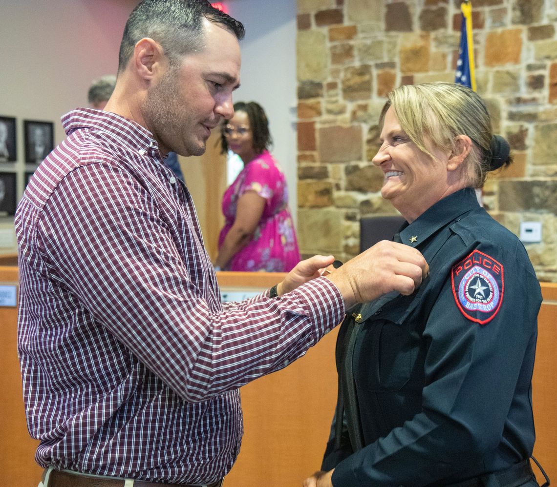 Vicky Steffanic has her police chief badge pinned on her uniform by husband Matthew Steffanic during the Bastrop City Council meeting April 11. Courtesy photo / City of Bastrop