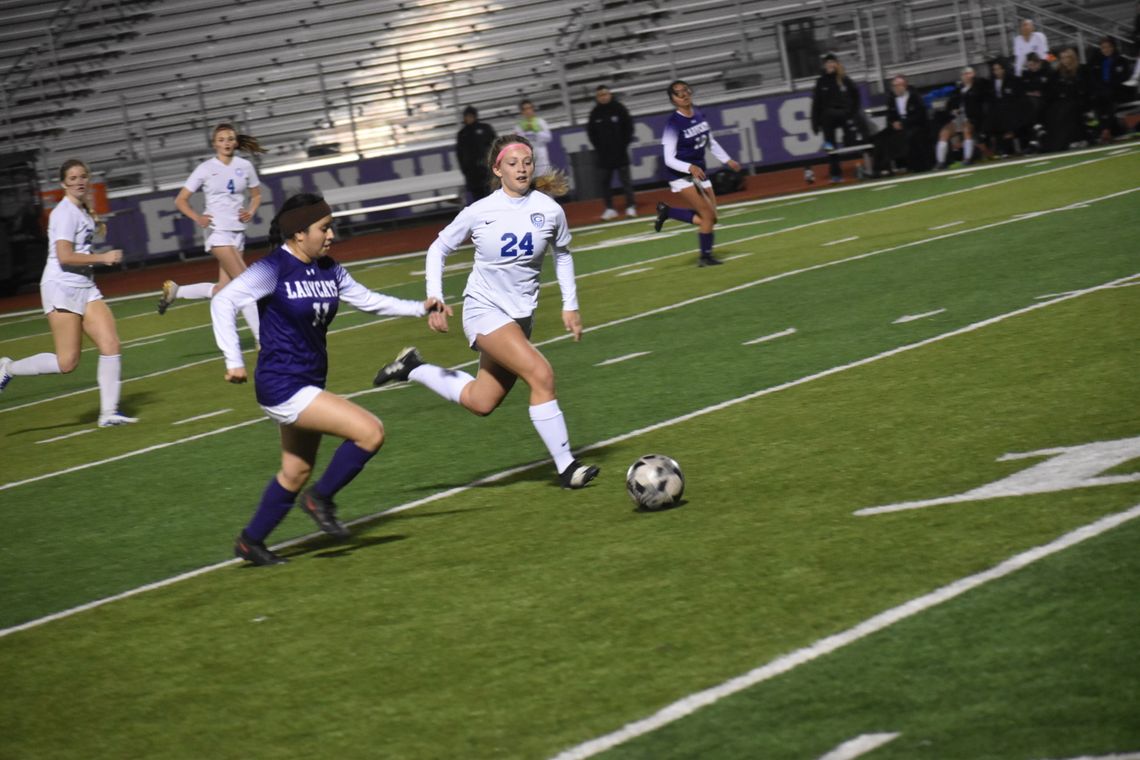 Katelyn Muñoz battles a Georgetown player for possession. Photo by Quinn Donoghue