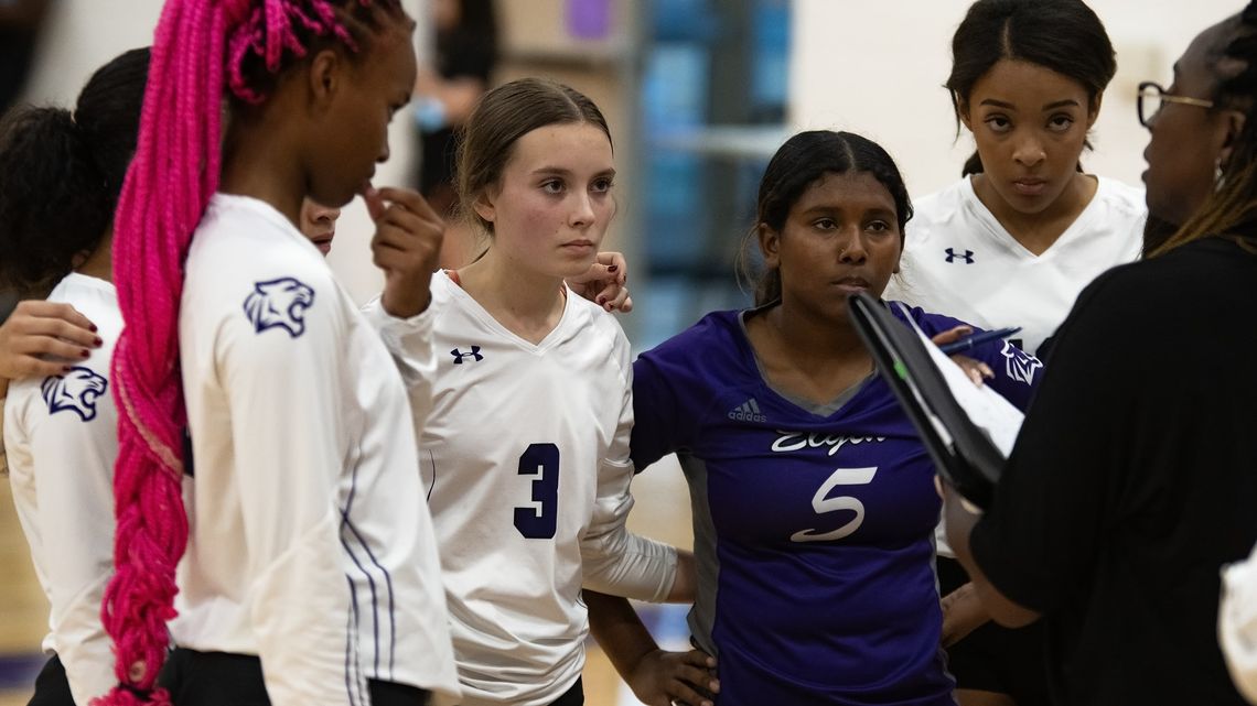 Elgin High School varsity volleyball freshman Meta Elliott (3) and sophomore Trinity Martinez (5) listen to head coach Patricia Rivers-Taylor (right) on Aug. 25 during a Lady Wildcats’ home match vs. Meridian World School. Photo by Marcial Guajardo