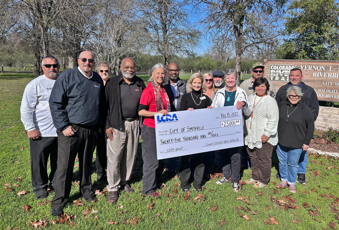 LCRA representatives present a $25,000 grant to Smithville officials for new signs at Vernon L. Richards Riverbend Park. The grant is part of LCRA’s Community Development Partnership Program. Pictured are, from left, Jack Page, Smithville director of public works and utilities; Robert Tamb...