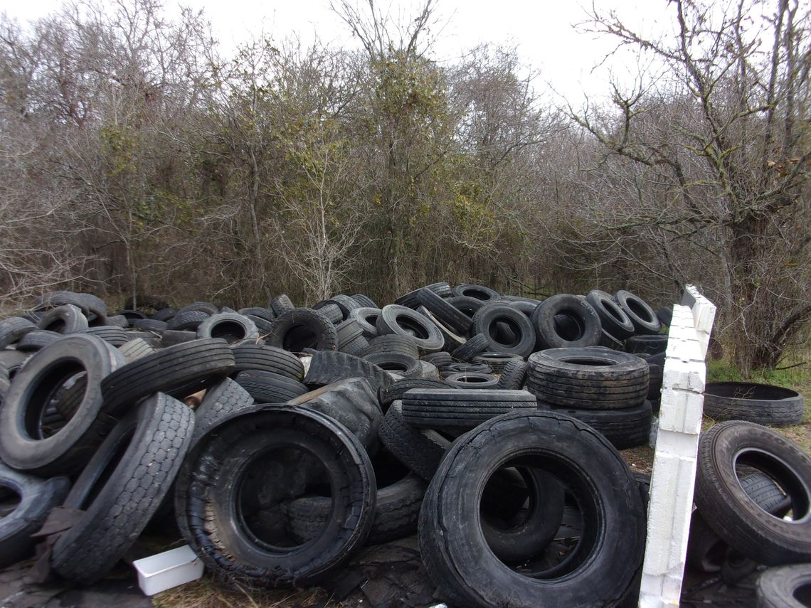 Tires litter a Cedar Creek property after being illegally dumped at the location.   Facebook / Bastrop County Sheriff’s Office