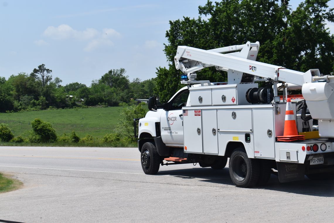 An Oncor vehicle leaves the scene of a downed power line on Texas 95 in Elgin March 31. Photo by Fernando Castro