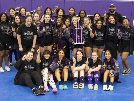 The Elgin girls powerlifting team celebrates after winning first place at the Elgin Wildcat Invitational. Photo by Erin Anderson