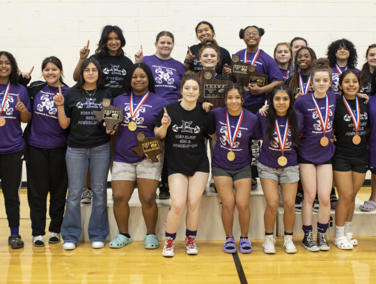 Elgin’s girls powerlifting team celebrates winning first at the regional meet in Elgin March 4. Photo by Erin Anderson