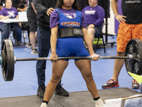 Elizabeth Nunez competes with Coach Jacob Rowe behind her during the regional powerlifting meet in Elgin March 4. Photo by Erin Anderson