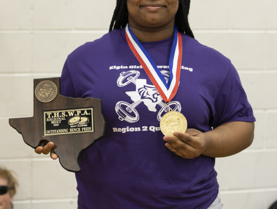 Nya Kirk Jones stands with her award earned at the regional powerlifting meet in Elgin March 4. Photo by Erin Anderson