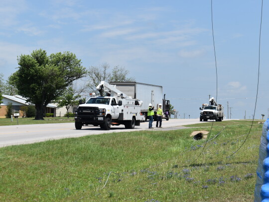Oncor personnel assess the situation of a downed power line on Texas 95 in Elgin March 31. Photo by Fernando Castro