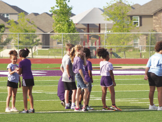 A group of young Lady Wildcat athletes eagerly wait together in line to compete in the 20-yard shuttle drill. Photo by Andrew Salmi