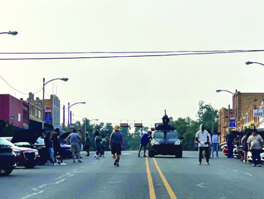 Civilians and talent mix among the souped-up rides, while the car rig resets for another shot. Photo by Niko Demetriou