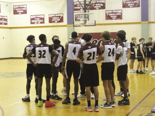 The Bastrop High School boys varsity basketball team huddles for a timeout on Monday, June 26 during a summer league scrimmage against Cedar Creek High School in Bastrop. Photo by Andrew Salmi