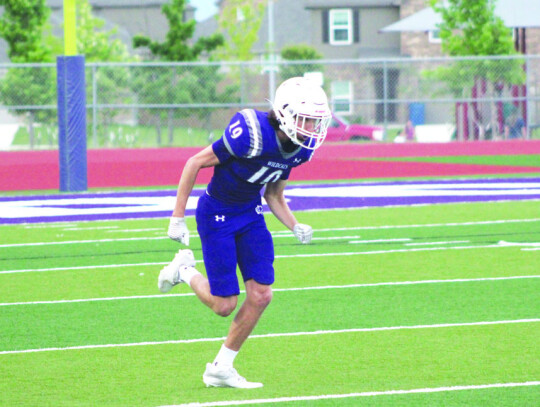 Wildcats varsity football senior wide receiver Blake Courtney runs a route upfield on May 19 during Elgin’s spring football scrimmage held at Wildcat Stadium. Photo by Andrew Salmi