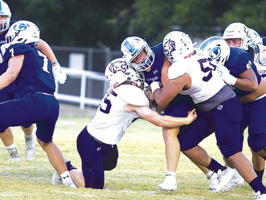 Elgin sophomore linebacker Matthew Clear (left) and senior defensive lineman Dennis Lavigne (right) swarm around a Lampasas ball carrier on Aug. 25 during the Wildcats’ road opener against the Badgers. Photo courtesy of Hunter King / Lampasas Dispatch Record