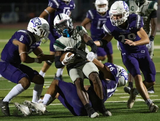 Wildcats varsity football senior defensive back Anthony Alvarez (8), senior defensive end Payton Grant (26) and junior linebacker Jackson Clowdus (29) swarm an opposing player on Sept. 8 during an Elgin home game vs. Rudder. Photo by Marcial Guajardo