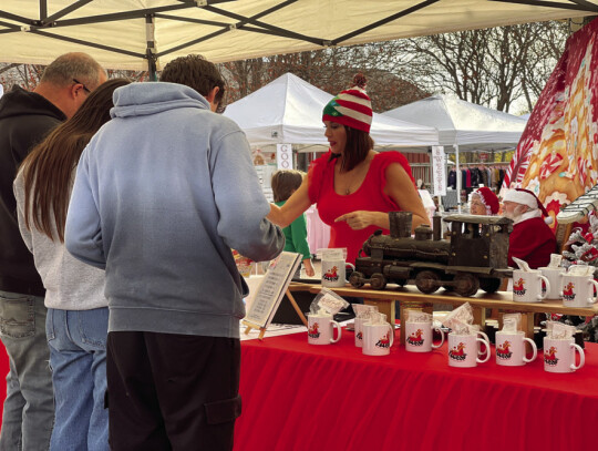 Elgin Chamber of Commerce President Veronica Seever distributing mugs for the event.