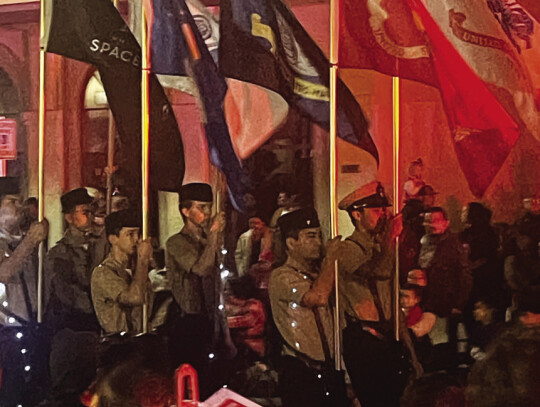 Local ROTC youth marching in line with flags held high. Photo by Niko Demetriou