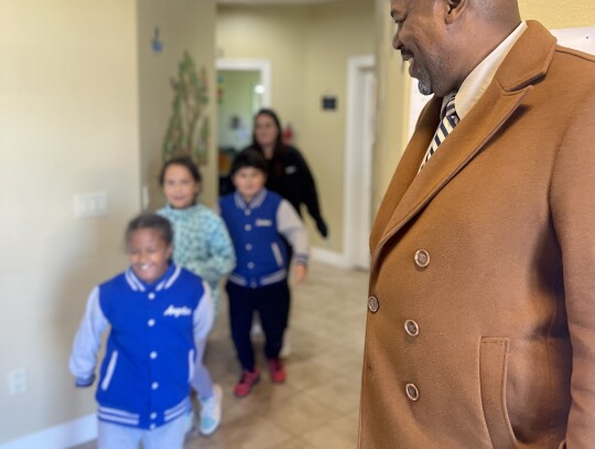 Charles Wilson gets a few hugs from his “champions” as they pass in the halls, walls decorated with the children’s artwork. Photo by Niko Demetriou