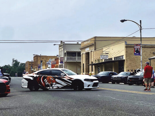 Civilians and talent mix among the souped-up rides, while the car rig resets for another shot. Photo by Niko Demetrio