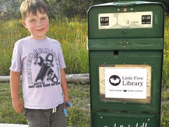 Augie Bidwell with his new Little Free Library, courtesy of Elgin Courier. Sign and design are a work in progress. Photo courtesy of Elisha Bidwell