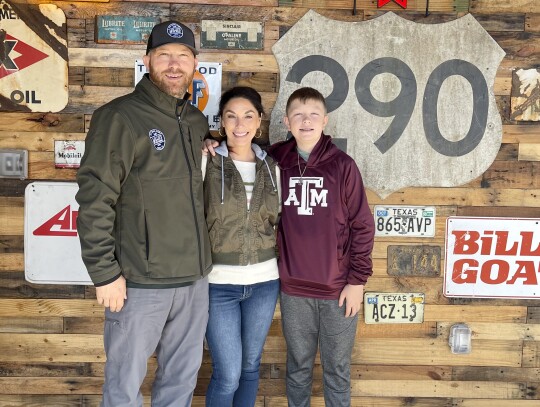 Owners Cody and Stacy, and their oldest son Miles Mauck, on stage in the restaurants rear. The old Elgin signs that decorate come from Cody’s father, Robert Mauck. Photo by Niko Demetriou