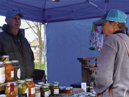 Mike Bittner’s table and tent, lined with jarred goods. The Elgin Farmers’ Market operates rain or shine. Courtesy photo by Lillian Gates